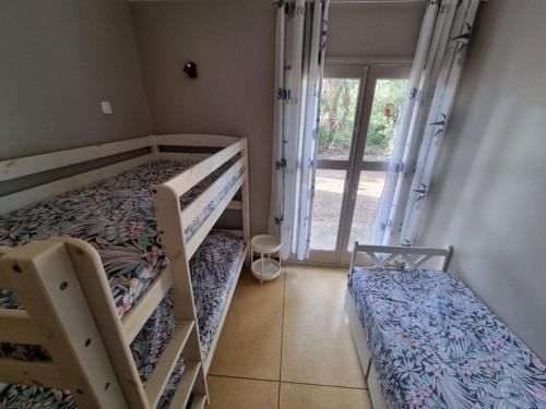 une chambre avec deux lits superposés et une fenêtre dans l'établissement Ground floor house Les Issambres, à Roquebrune-sur Argens