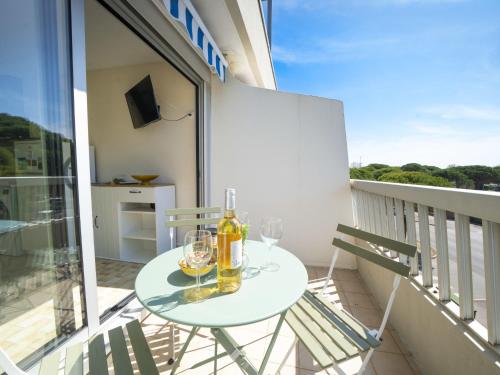- un balcon avec une table et des verres à vin dans l'établissement Apartment La Frégate-14 by Interhome, au Grau-du-Roi