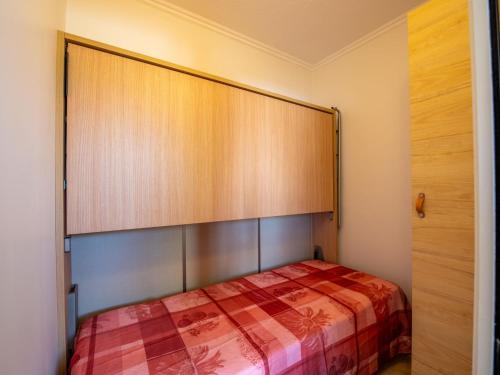 une chambre avec un lit avec une grande tête de lit en bois dans l'établissement Apartment Porto di Mar-17 by Interhome, à Cavalaire-sur-Mer