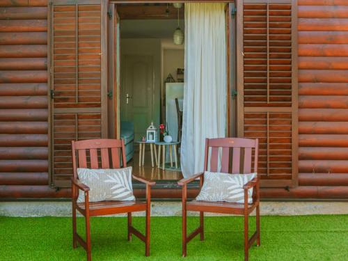 two chairs and a table in front of a house at Holiday Home IV-AN by Interhome in Perušić