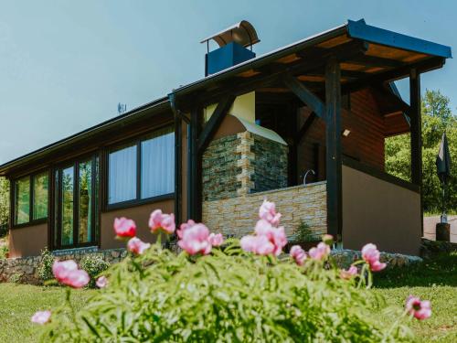 a house with pink flowers in front of it at Holiday Home IV-AN by Interhome in Perušić