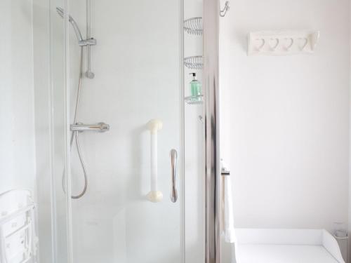a white bathroom with a shower with a glass door at Holiday Home Bothan Aonghais by Interhome in Kilmuir