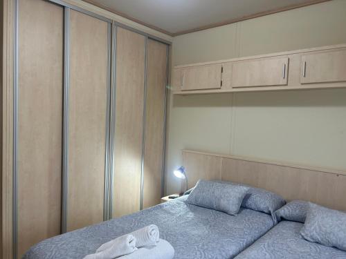 a bedroom with a bed with blue sheets and cabinets at EL HOGARIN DE ARRIONDAS in Arriondas