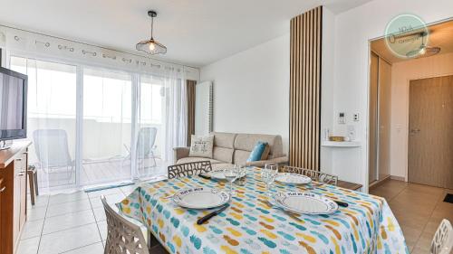 un salon avec une table et un canapé dans l'établissement Residence les Oyats, à Les Bussolleries