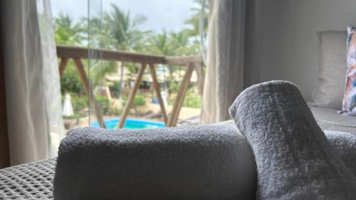 a person with their feet up on a couch looking out a window at Pousada Oceano Atlântico in Marau