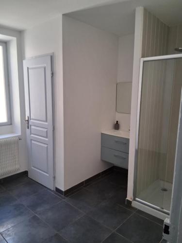 La salle de bains est pourvue d'un miroir et d'une porte blanche. dans l'établissement Chez Sylvie, à Carcassonne