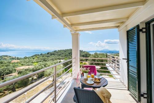 a balcony with a table and chairs and a view of the ocean at elli epavlis private pool starlink wifi near barbati in Spartýlas
