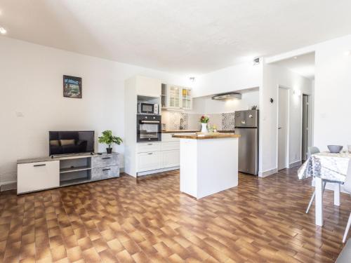 une cuisine avec des armoires blanches et un plancher en bois dans l'établissement Apartment Port Richelieu 1 by Interhome, au Cap d'Agde