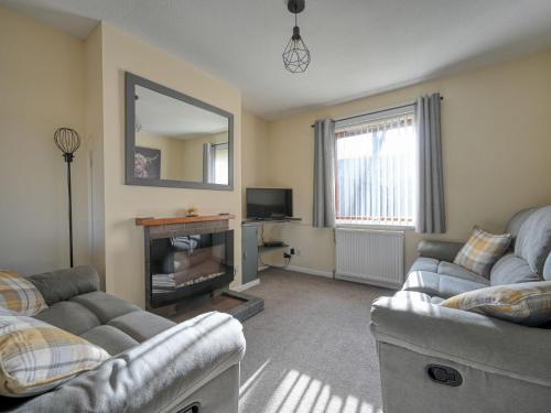 a living room with two couches and a mirror at Holiday Home Appletree by Interhome in Muir of Ord