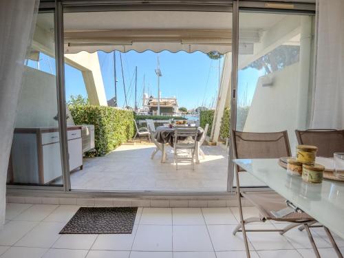 une cuisine et une salle à manger avec vue sur un patio dans l'établissement Apartment Les Rivages d'Ulysse by Interhome, au Grau-du-Roi