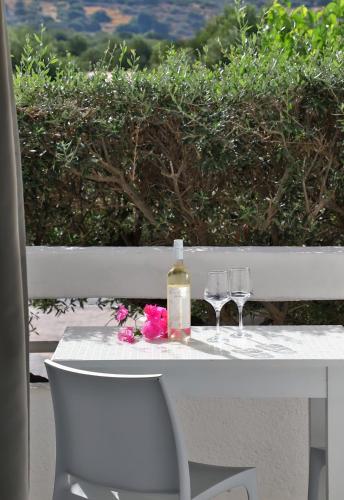 a table with two glasses and a bottle of wine at Elounda Krini Hotel in Elounda