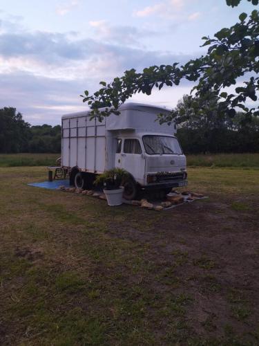 un camion blanc est garé dans un champ dans l'établissement Nuit insolite, à La Celle-sous-Gouzon