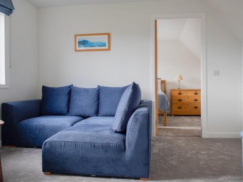 a blue couch in a living room with a mirror at Holiday Home The Old Post Office by Interhome in Saasaig