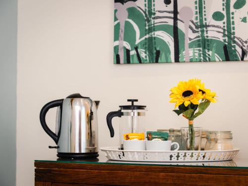 a tray with a coffee pot and a flower on a table at Studio Wayside Loft by Interhome in Drumnadrochit