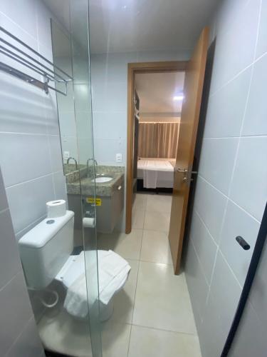 a bathroom with a toilet and a glass shower at MANAÍRA APART HOTEL in João Pessoa