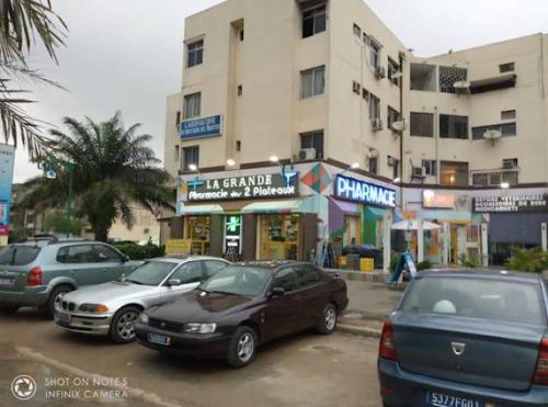 a parking lot with cars parked in front of a building at résidence Nathalia in Abidjan