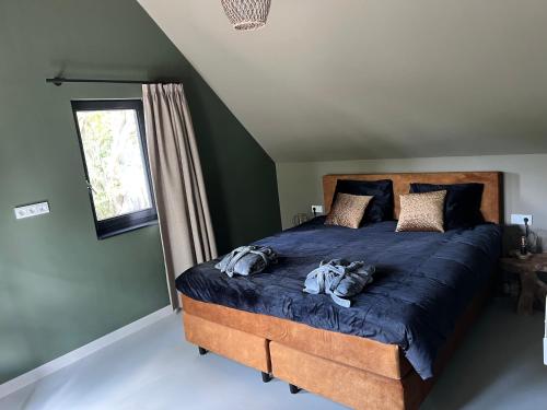 a bedroom with a large bed with a blue comforter at De Geluksbrenger in Spanga