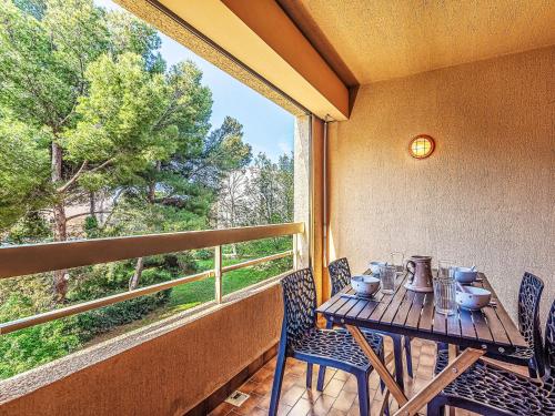 une table et des chaises sur un balcon avec une fenêtre dans l'établissement Studio Les Regates-9 by Interhome, à Hyères