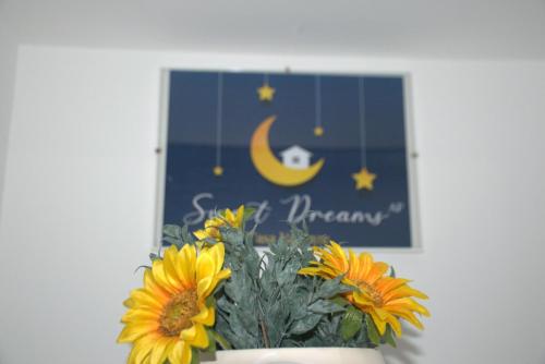 a bouquet of sunflowers in a vase next to a picture at Sweet dreams AF in Palermo