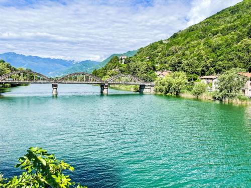 a bridge over a river with mountains in the background at Apartment Buongusto by Interhome in Bugiallo