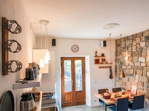 a kitchen with a table and a stone wall at Holiday Home Kira by Interhome in Molazzana