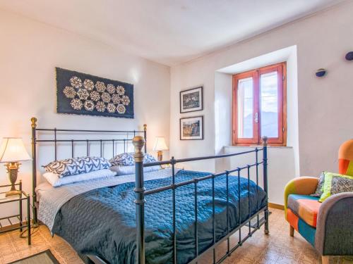 a bedroom with a bed and a chair at Holiday Home Kira by Interhome in Molazzana