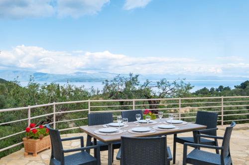 a table and chairs on a patio with a view at elli epavlis private pool starlink wifi near barbati in Spartýlas