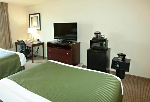 a hotel room with a bed and a flat screen tv at Cobblestone Inn & Suites - Langdon in Langdon