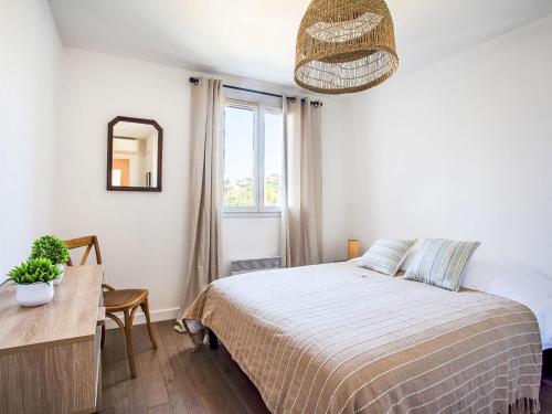 une chambre avec un lit, une table et un miroir dans l'établissement Apartment Vaugrenier Présidence by Interhome, à Villeneuve-Loubet