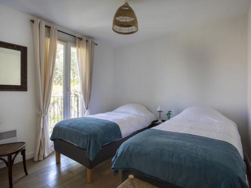deux lits dans une chambre avec une fenêtre dans l'établissement Apartment Vaugrenier Présidence by Interhome, à Villeneuve-Loubet