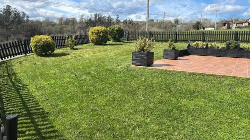 a yard with green grass and a fence at EL HOGARIN DE ARRIONDAS in Arriondas