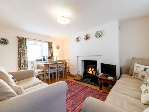 ein Wohnzimmer mit zwei Sofas und einem Kamin in der Unterkunft Holiday Home Seaforth Cottage by Interhome in Gorran Haven