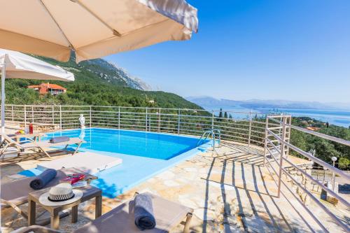 a villa with a swimming pool and a view of the ocean at elli epavlis private pool starlink wifi near barbati in Spartýlas