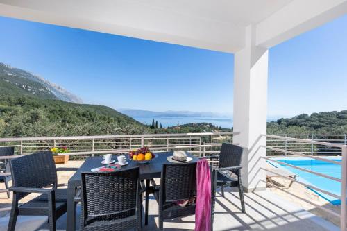 a dining table on a balcony with a view of the ocean at elli epavlis private pool starlink wifi near barbati in Spartýlas