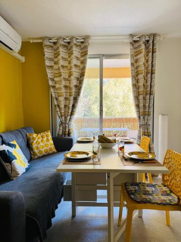 un salon avec une table et un canapé dans l'établissement Le Boulouris - stylish T2, à Saint-Raphaël