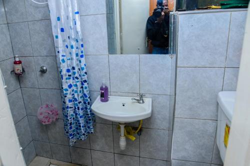 a bathroom with a sink and a shower at Faraja Apartment at Coral Bells in Nairobi