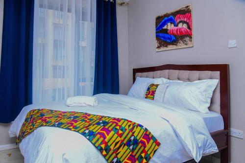 a bedroom with a bed with a colorful blanket on it at Faraja Apartment at Coral Bells in Nairobi