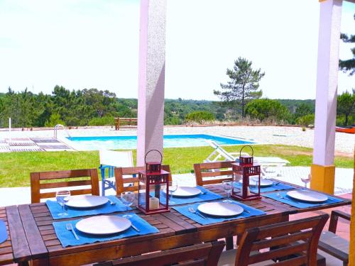 a wooden table with a blue table cloth and plates on it at Holiday Home Lago by Interhome in Alcácer do Sal