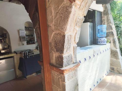 a kitchen with a window in a stone wall at Casa de las Conchas Cuernavaca in Cuernavaca