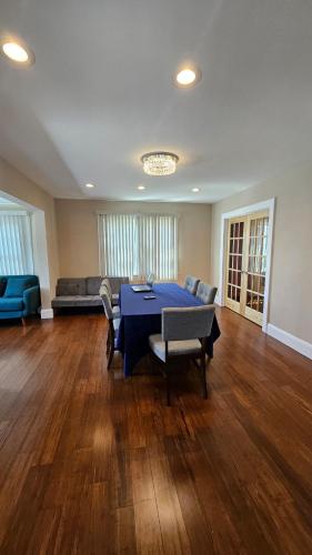 a living room with a blue table and chairs at The Heart of Hicksville House in Hicksville
