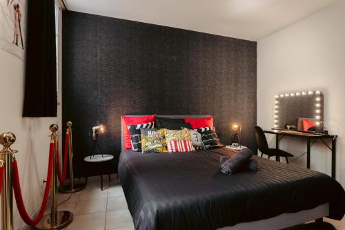 une chambre avec un grand lit avec des oreillers rouges dans l'établissement Olympia - Terrasse, Parking gratuit, Thème Cinéma, Coeur de ville, Rez de chaussée, Fibre, Tv 4K, à Saintes