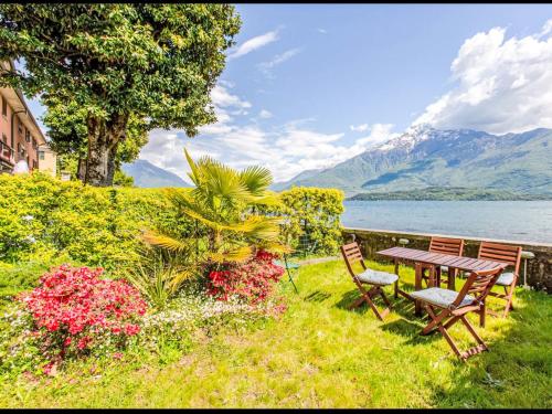 a picnic table and chairs in the grass next to a lake at Apartment La Sostra by Interhome in Domaso