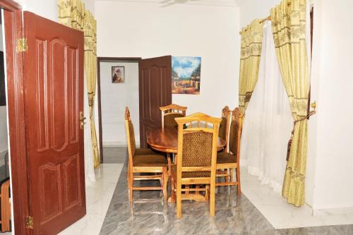 a dining room with a wooden table and chairs at Suite Dreams Luxe - Vesgrah Home in Kumasi