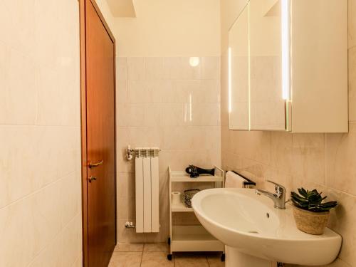 a white bathroom with a sink and a cabinet at Apartment Piazza San Giuseppe-6 by Interhome in Acquaseria