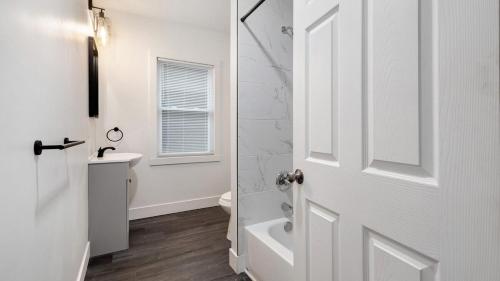 a white bathroom with a shower and a toilet at Walk to Niagara Falls! 12 Bedrooms! in Niagara Falls