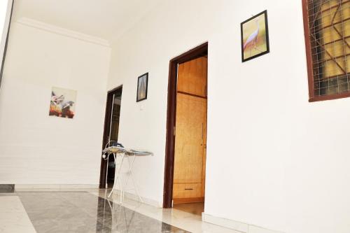 a hallway with a wooden door and a chair at Suite Dreams Luxe - Vesgrah Home in Kumasi