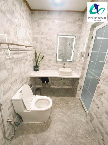 a bathroom with a toilet and a sink at Infinity Beach Dhigurah in Dhigurah