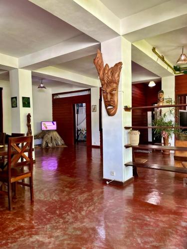 a living room with a statue of a face on the wall at Appartement ATIALA in Hell-Ville