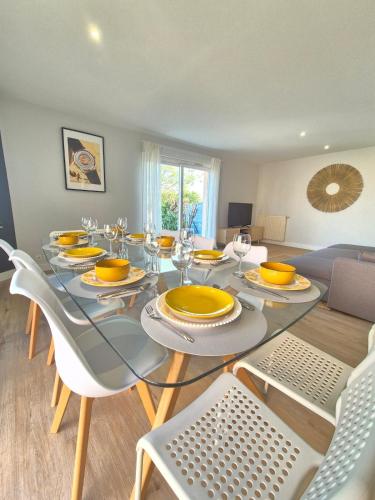 une salle à manger avec une table et des chaises en verre dans l'établissement Le Clos Des Farges #Clim#Parking#Terrasse, à Clermont-Ferrand