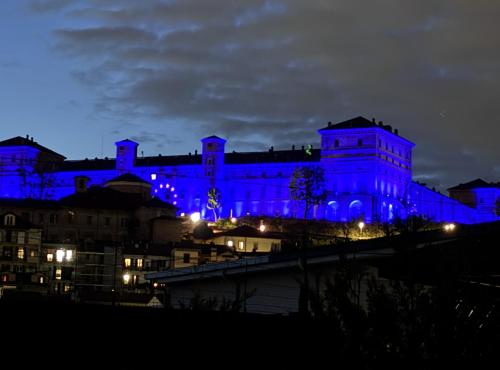 a building lit up in blue at night at Nina Camera matrimoniale in Appartamento in Moncalieri